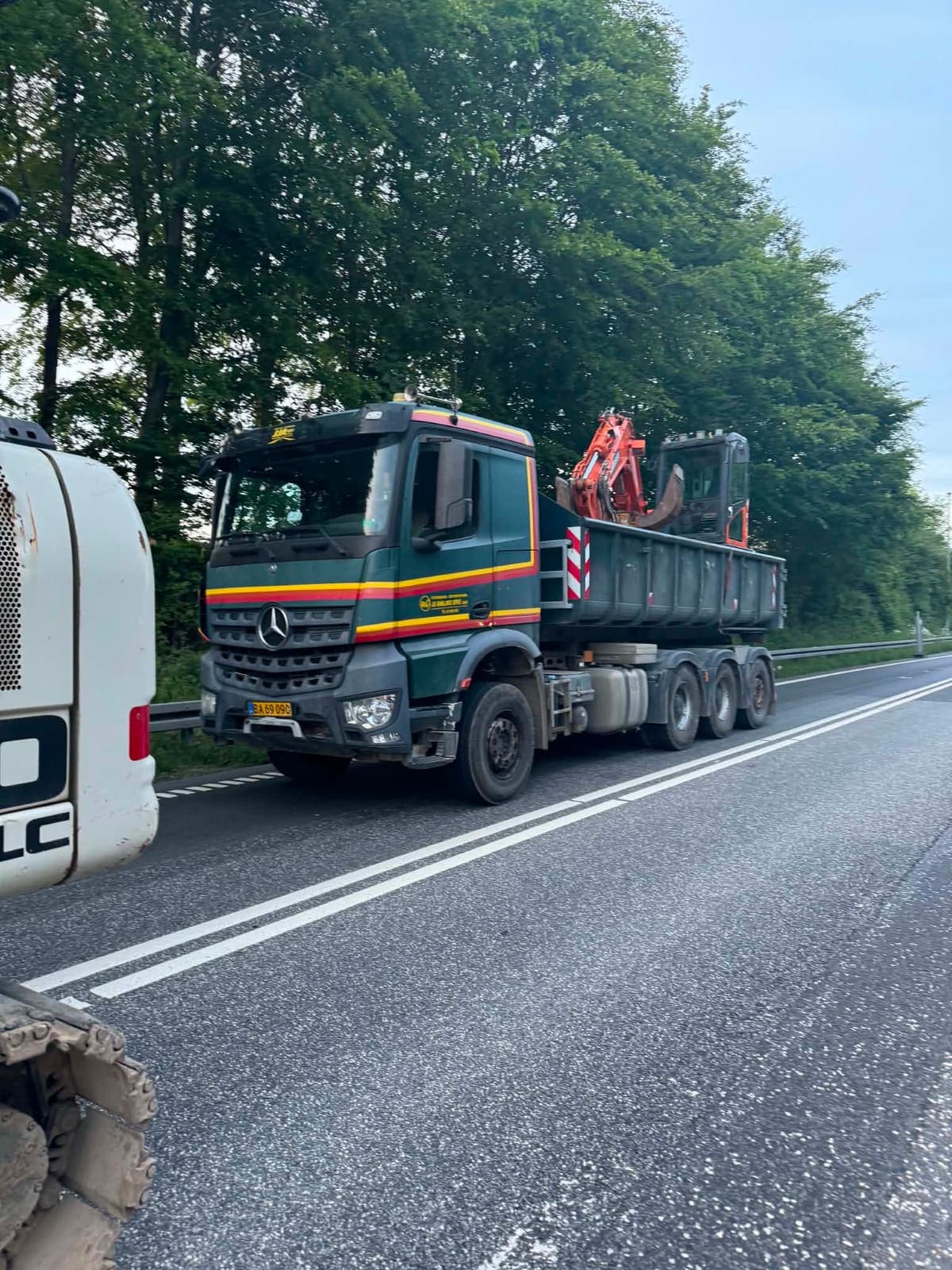 Containerbil med anhænger og gravemaskine på ladet
